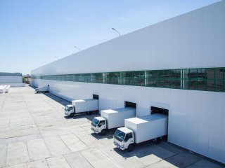 Trucks at the docks of a warehouse. Photo by Alba_alioth/Shutterstock.com