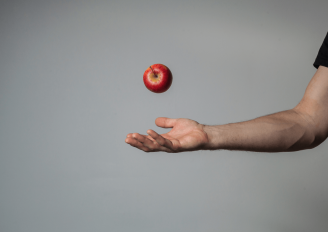 Een hand die een appel opgooit. Foto van Aleksandr Rudoj/Shutterstock.com